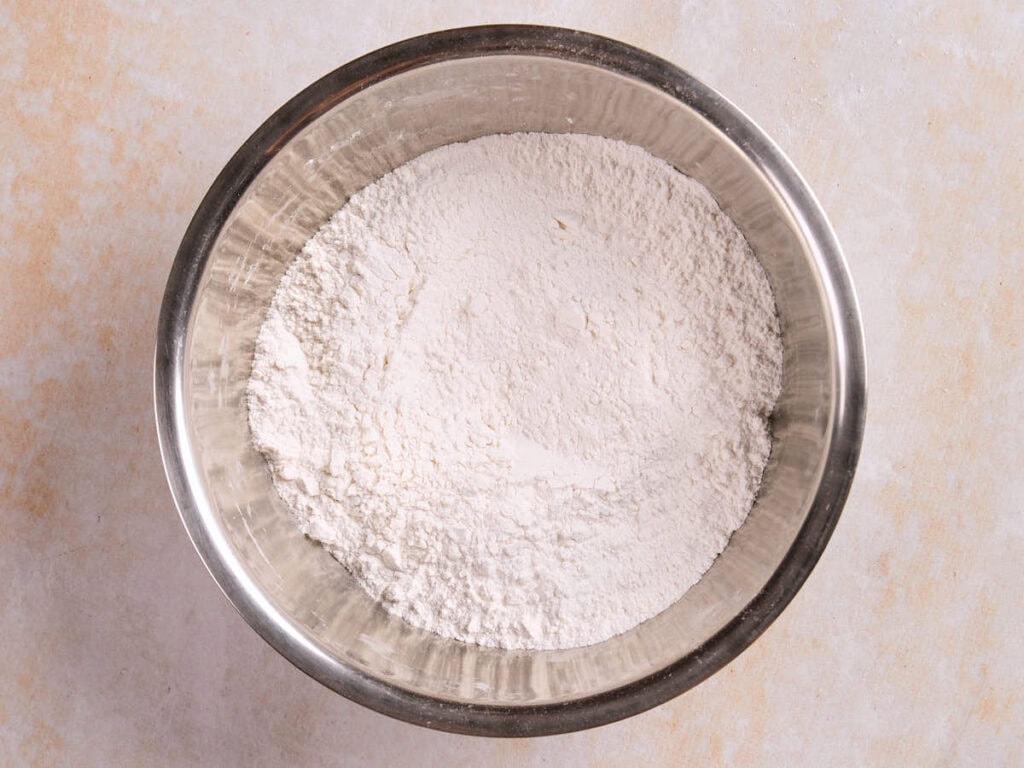 A metal bowl filled with white flour.