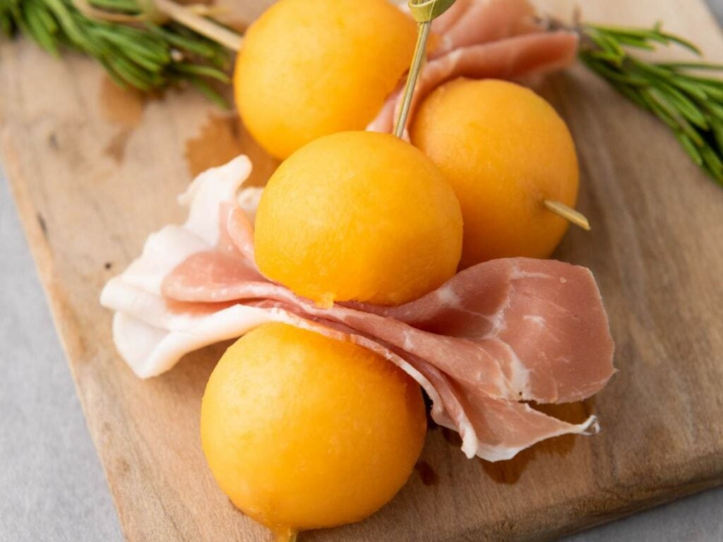 Skewer with slices of cantaloupe prosciutto and round pieces of cantaloupe melon.