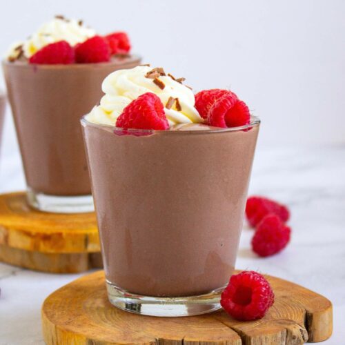 Cottage cheese pudding topped with whipped cream, chocolate shavings, and fresh raspberries.