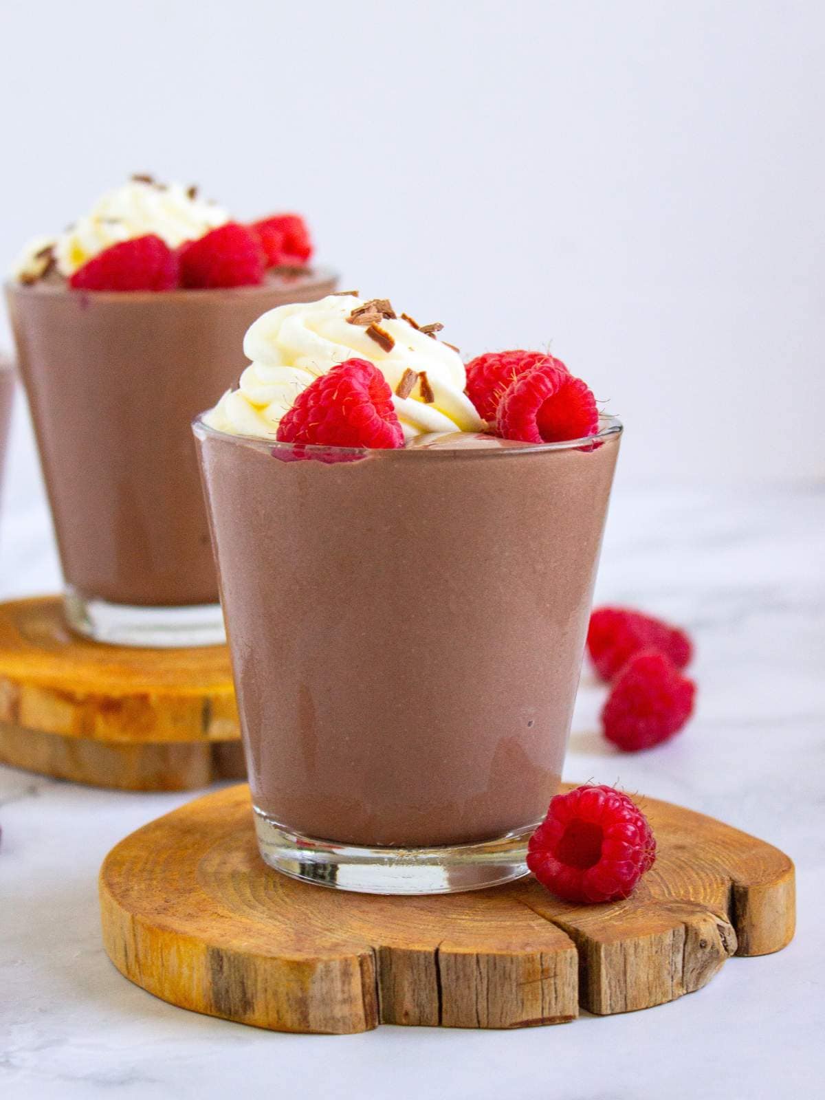 Cottage cheese pudding topped with whipped cream, chocolate shavings, and fresh raspberries.