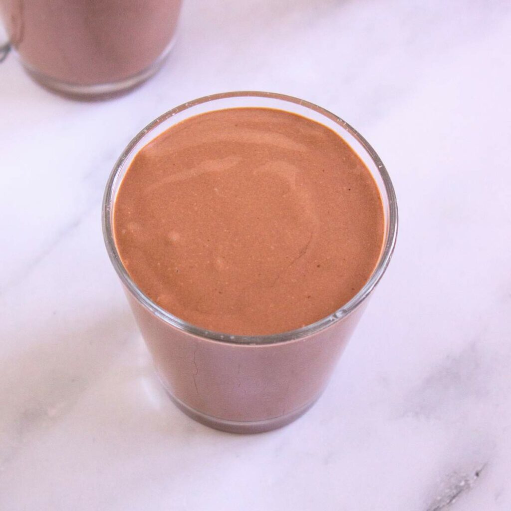 A glass filled with cottage cheese pudding.