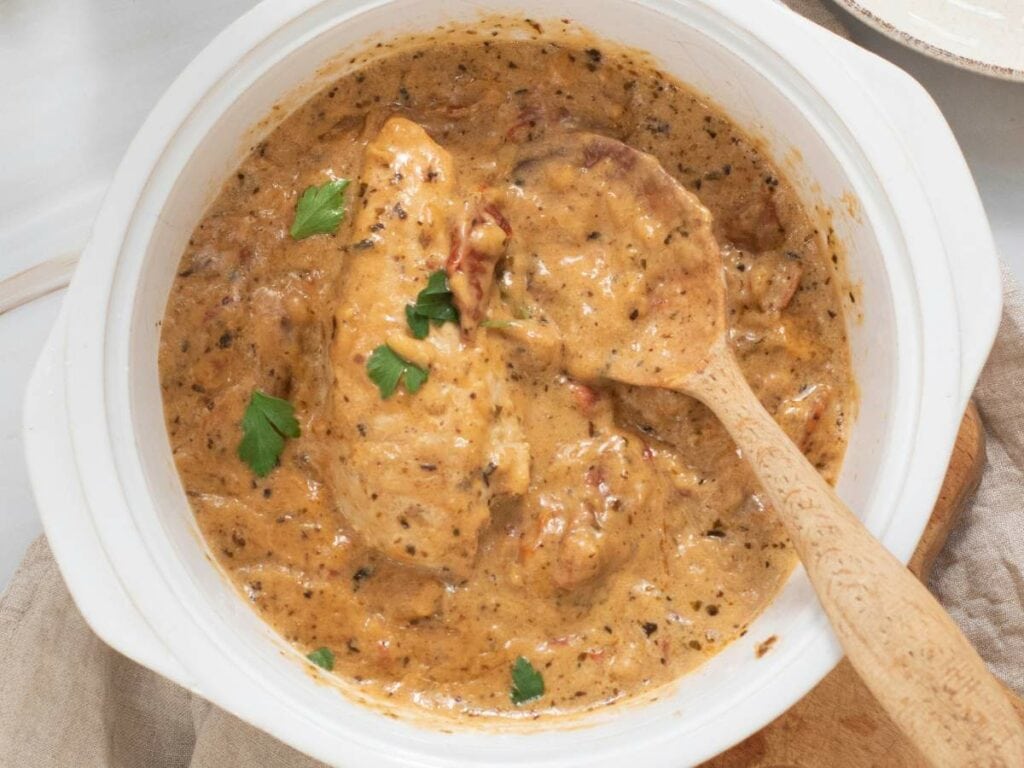 A marry me chicken skillet garnished with parsley.