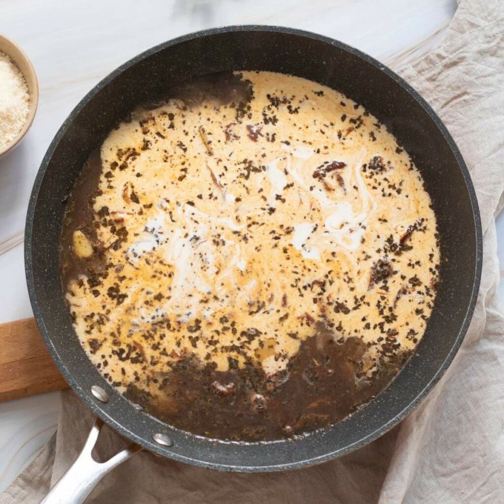 A skillet containing a creamy sauce.