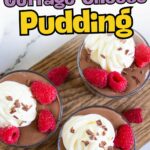 Three glass cups of chocolate cottage cheese pudding topped with whipped cream, raspberries, and chocolate shavings on a wooden board.