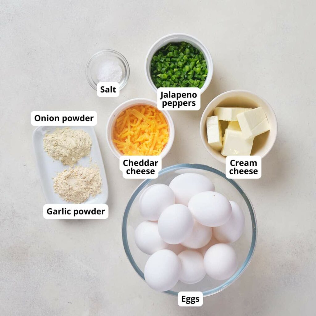 Labeled ingredients for jalapeño popper egg bites on a white surface.