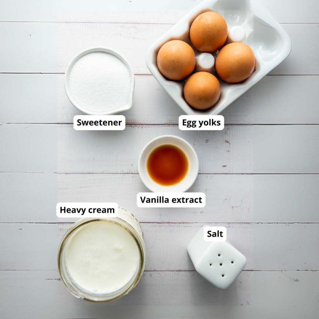 Five ingredients for a creme brulee recipe on a white surface.