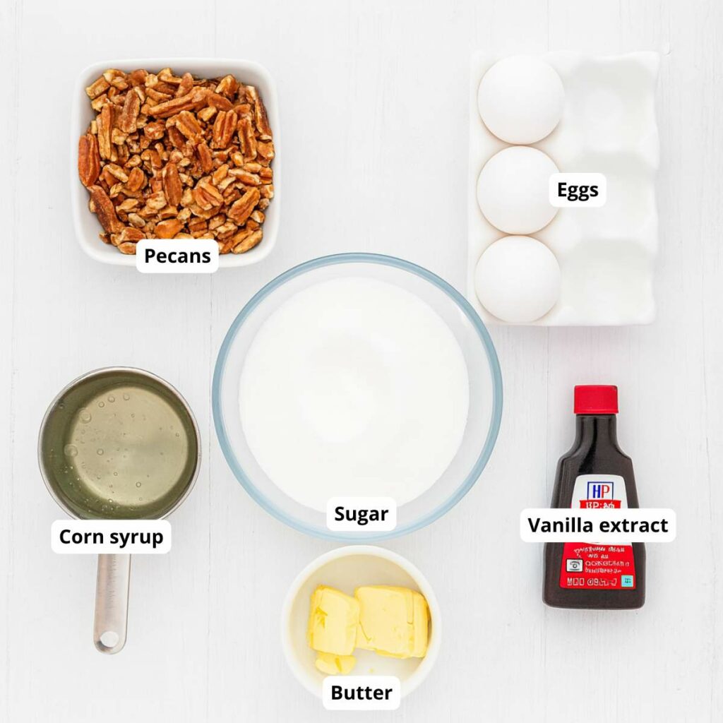 Top-down view of labeled ingredients for the filling of simple pecan pie recipe on a white surface.