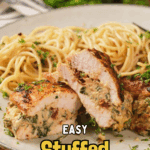 A plate of stuffed chicken breast sliced open to show creamy filling, served with a side of spaghetti, garnished with herbs.